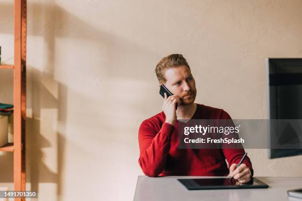 a handsome blond businessman calling somebody using his mobile phone while working in the office - red pen single object stock pictures, royalty-free photos & images