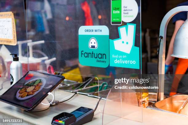 food kiosk with deliveroo and uber eats signs - deliveroo stock pictures, royalty-free photos & images