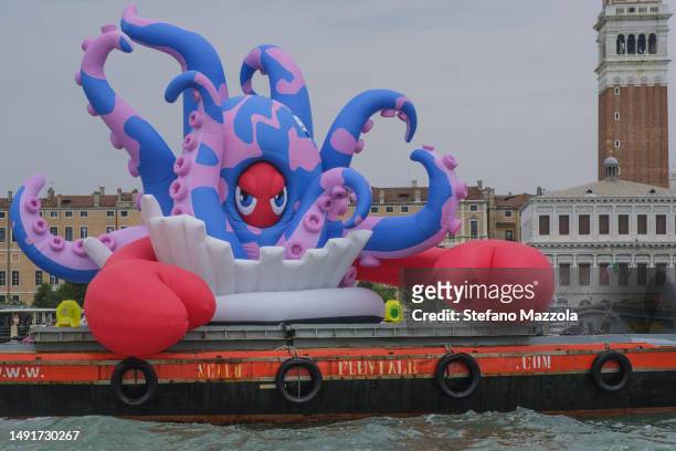 Boat carries a giant inflatable lobster titled: Lobster Octopus from Pompeii created by British artist Philip Colbert in Venice's San Marco Basin...