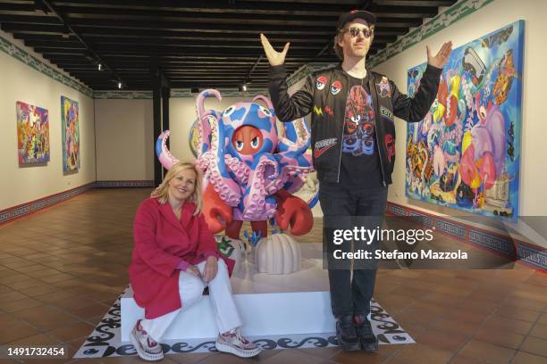 British artist Philip Colbert and Patricia Low pose for a portrait alongside works on display at the 'Patricia Low Venice' Art Gallery during the...