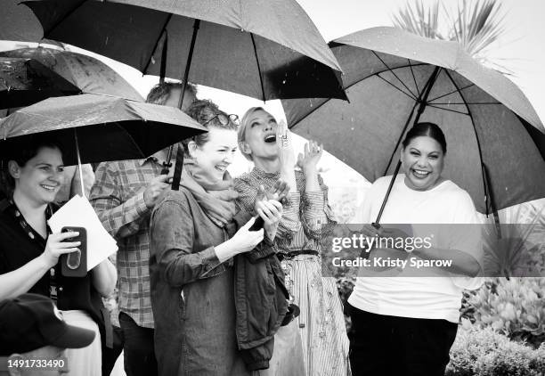 Cate Blanchett and Deborah Mailman laugh during the rain at "The New Boy" photocall at the 76th annual Cannes film festival at Palais des Festivals...