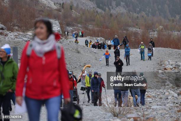 Climate activists arrive below the receding Morteratsch glacier with banners to campaign for an upcoming climate-related referendum on May 20, 2023...
