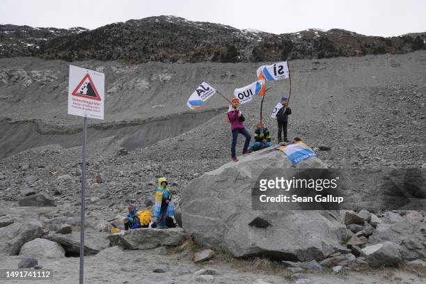The children of climate activists wave flags with the word "Yes" in German, French and Italian below a moraine of the receding Morteratsch glacier...