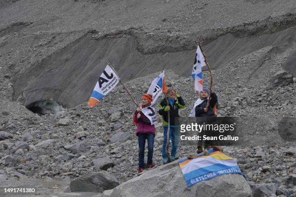 The children of climate activists wave flags with the word "Yes" in German, French and Italian below the receding Morteratsch glacier during a...