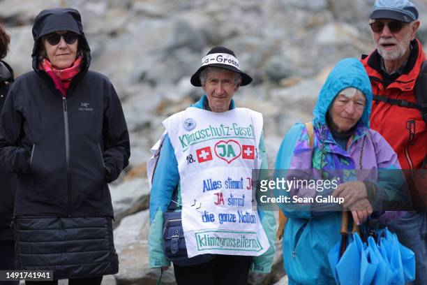 Climate activists gather below the receding Morteratsch glacier with banners to campaign for an upcoming climate-related referendum on May 20, 2023...