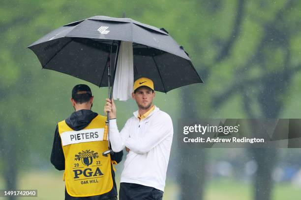 Thomas Pieters of Belgium waits to putt on the eighth green as caddie Adam Marrow holds an umbrella during the third round of the 2023 PGA...