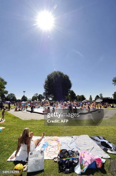 Woman rests as people enjoy the sun at an outdoor pool in the recreation resort Binnenmaas in Mijnsheerenland, the Netherlands, on July 24, 2012....