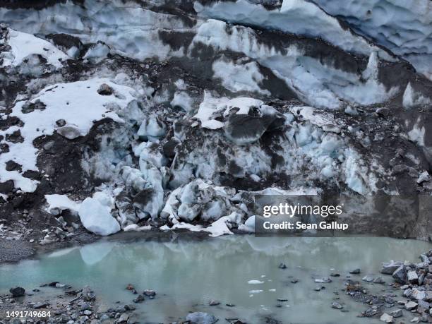 In this aerial view a pond of meltwater lies below a collapsed portion of the receding Morteratsch glacier on May 20, 2023 near Pontresina,...