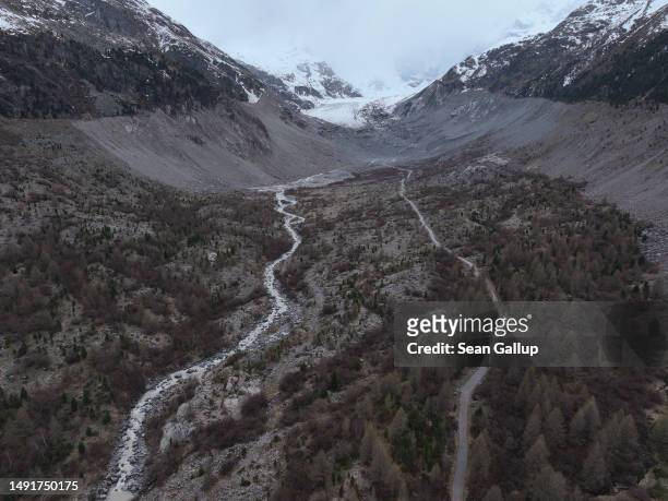 In this aerial view a river of meltwater runs through a basin of the receding Morteratsch glacier once filled completely in the 1950s on May 20, 2023...