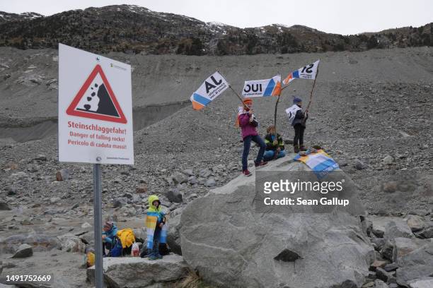 The children of climate activists wave flags with the word "Yes" in German, French and Italian below a moraine of the receding Morteratsch glacier...