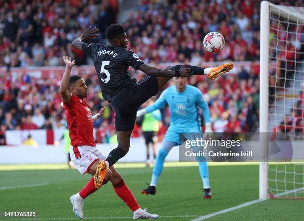 Thomas Partey of Arsenal jumps for the ball with Renan Lodi of Nottingham Forest during the Premier League match between Nottingham Forest and...