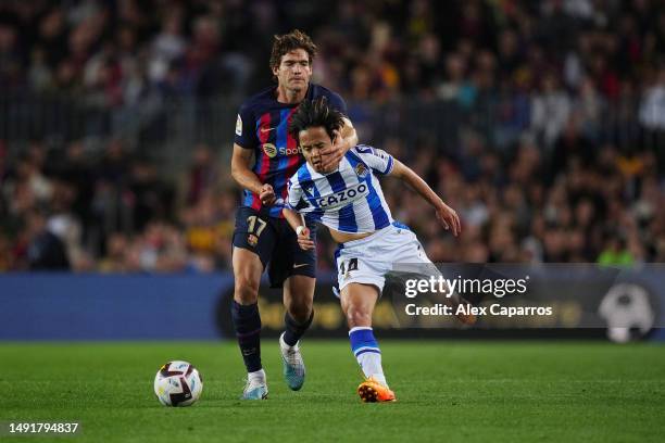 Takefusa Kubo of Real Sociedad is challenged by Marcos Alonso of FC Barcelona during the LaLiga Santander match between FC Barcelona and Real...