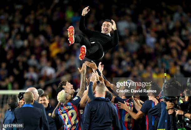 Xavi, Head Coach of FC Barcelona, is thrown into the air as players of FC Barcelona celebrate being crowned the League Champions of the LaLiga...