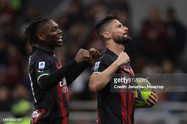 Olivier Giroud of AC Milan holds the matchball as he celebrates with team mate Rafael Leao after scoring to complete his hat-trick the Serie A match...