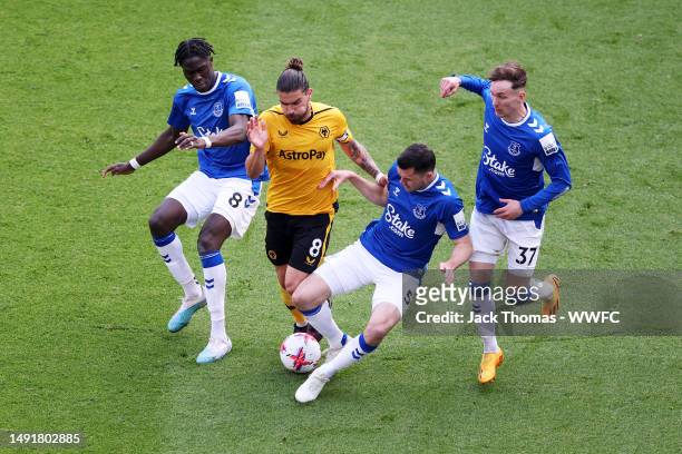 Ruben Neves of Wolverhampton Wanderers is challenged by Michael Keane, James Garner and Amadou Onana of Everton FC during the Premier League match...