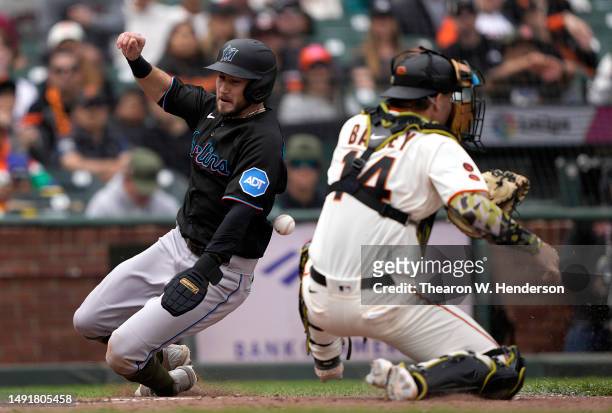 Garrett Hampson of the Miami Marlins scores as Patrick Bailey of the San Francisco Giants can't handle the throw in the top of the eighth inning at...
