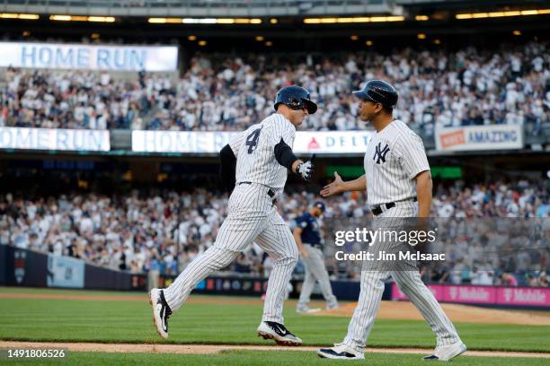 Anthony Rizzo of the New York Yankees celebrates his first inning home run against the Tampa Bay Rays with third base coach Luis Rojas at Yankee...