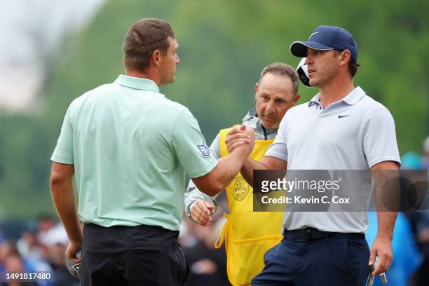 Bryson DeChambeau of the United States shake hands Brooks Koepka of the United States on the 18th green during the third round of the 2023 PGA...