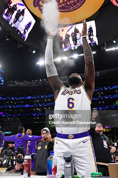 LeBron James of the Los Angeles Lakers throws chalk into the air before playing against the Denver Nuggets in game three of the Western Conference...