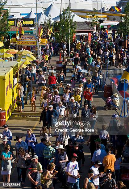 Thousands of people walk through the midway in Stampede Park, sampling foods such as pizza, hamburgers, and hot dogs on July 6, 2012 in Calgary,...