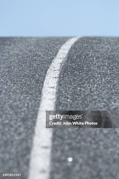 single white line in the middle of an asphalt road. - tejer stock-fotos und bilder