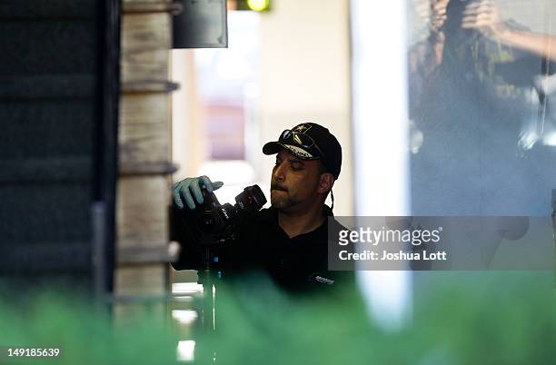 Federal Bureau of Investigation agent takes photos as he investigates inside the apartment building where suspect James Holmes lived July 24, 2012 in...