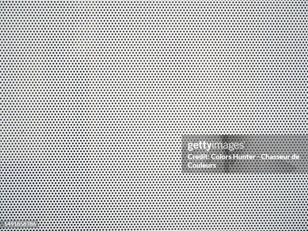 close-up of a perforated metal plate painted white in brussels, belgium - gepunktet stock-fotos und bilder