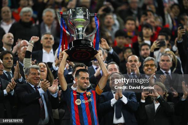 Sergio Busquets of FC Barcelona lifts the LaLiga trophy next to FC Barcelona president Joan Laporta following the LaLiga Santander match between FC...