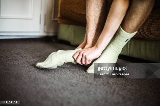 low section male teenager putting on socks at  home - male feet - fotografias e filmes do acervo