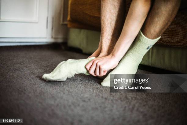 low section male teenager putting on socks at  home - adjust socks bildbanksfoton och bilder