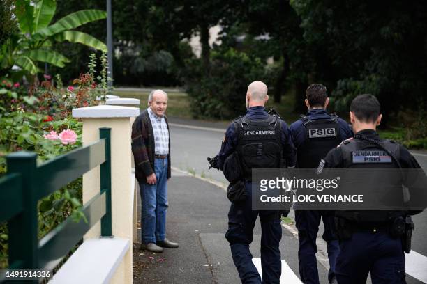 French gendarme and French gendarmes of the PSIG walk past a resident in a residential area, on July 4 in Montreuil-Juigne, western France, where law...