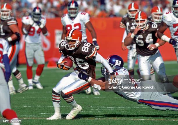 Wide receiver Dennis Northcutt of the Cleveland Browns tries to run with the football after catching a pass as he is tackled by linebacker Ryan...
