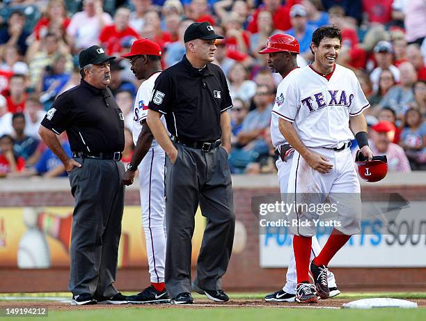 Ron Washington manager of the Texas Rangers speaks with umpire Tim Tschida for ejecting Ian Kinsler of the Texas Rangers from the game for disputing...