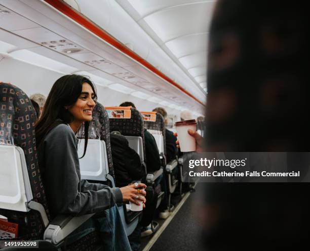 a happy woman on a plane - airline passengers stock-fotos und bilder