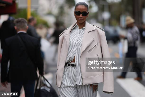 Film Festival Guest seen wearing a rose leather jacket, stripped blue and white two piece, blouse and pants and black leather sandals and black...