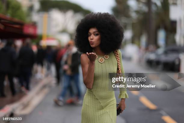 Film Festival Guest seen wearing a a long lime yellow dress and white puffer sandals, a flower chain and a brown statement bag during the 76th Cannes...