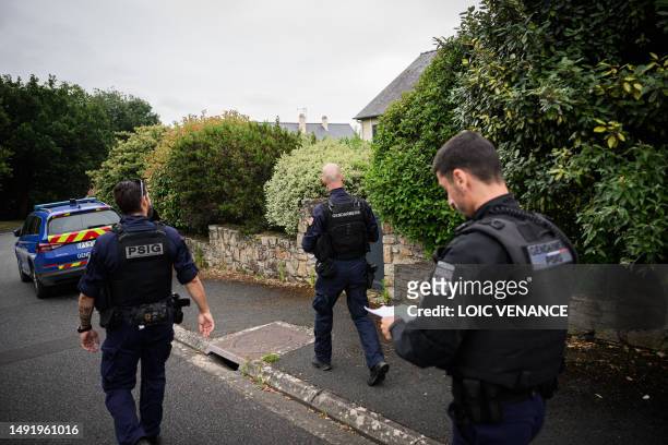 French gendarme and French gendarmes of the PSIG walk past a house in a residential area, on July 4 in Montreuil-Juigne, western France, where law...