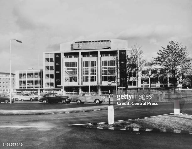 Traffic waits as a pedestrian crosses the road outside Fairfield Halls, an arts and conference centre in Croydon, London, England, circa 1965. The...