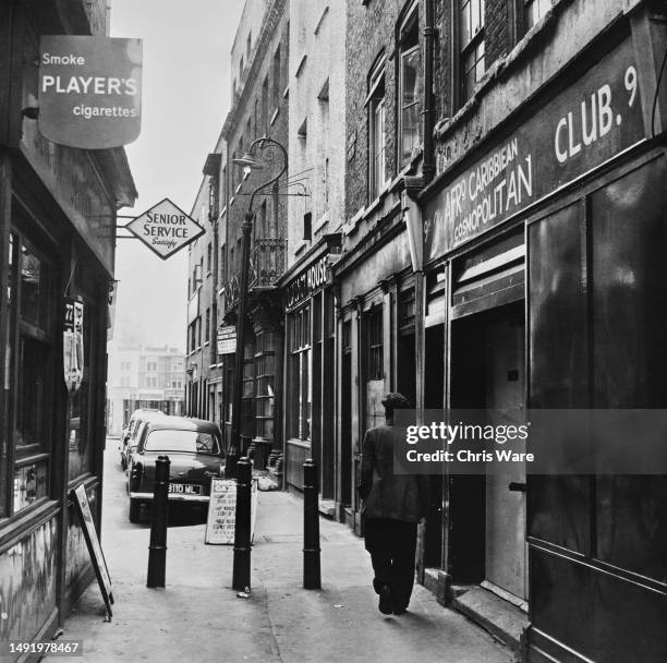 Signs reading 'Smoke Player's Cigarettes', 'Senior Service Satisfy' and 'Afro Caribbean Cosmopolitan Club' on a byway off Folgate Street in London,...