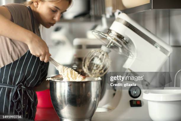 cake manufacturer mixing a batter. - electric whisk stock pictures, royalty-free photos & images