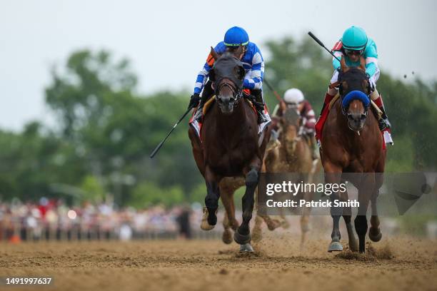 Jockey John Velazquez riding National Treasure rides alongside jockey Irad Ortiz Jr. #7 riding Blazing Sevens to cross the finish line first to win...