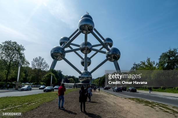 Tourists take a picture of the famous Atomium from the esplanade leading to the monument on May 21, 2023 in Brussels, Belgium. Renovated between 2004...