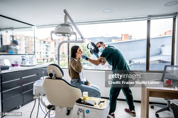 dentist/orthodontist photographing the teeth's of a patient at dentistry clinic - dental calculus stock pictures, royalty-free photos & images