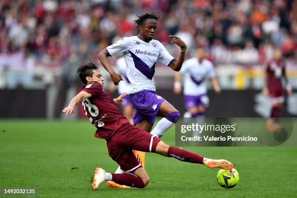 Cristian Kouame of ACF Fiorentina is challenged by Samuele Ricci of Torino FC during the Serie A match between Torino FC and ACF Fiorentina at Stadio...