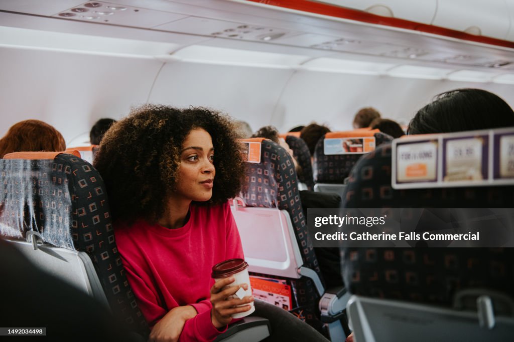 A young woman looks pensive on a plane