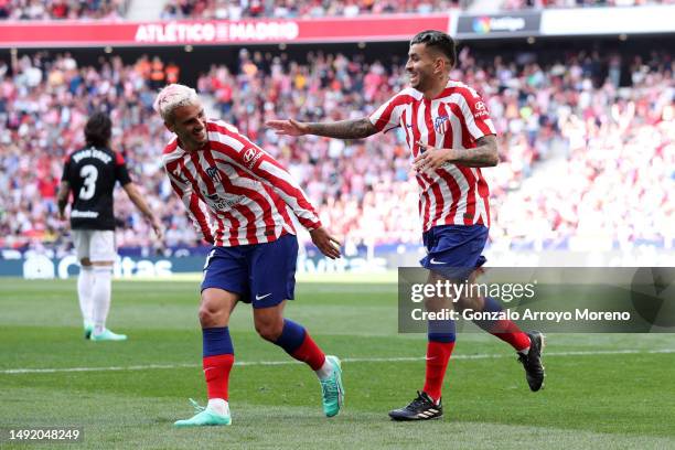 Angel Correa of Atletico Madrid celebrates with teammate Antoine Griezmann after scoring the team's third goal during the LaLiga Santander match...