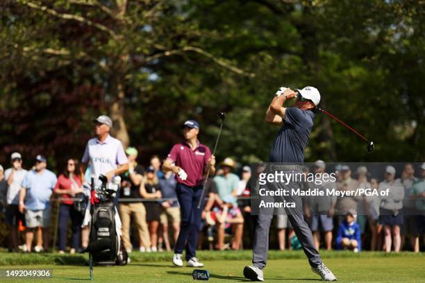 Phil Mickelson of the United States plays his shot from the eighth tee as Justin Thomas of the United States and caddie Jim 'Bones' Mackay look on...