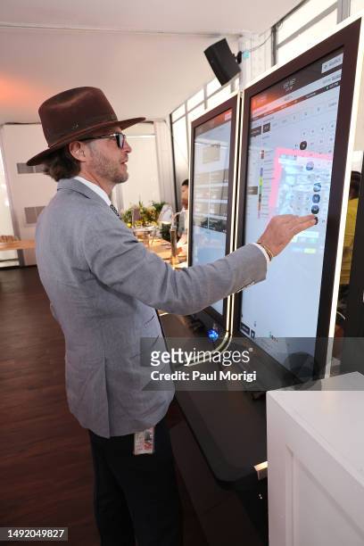 Aidan Butler inspects the betting machine during Black-Eyed Susan Day hosted by 1/ST at Pimlico Race Course on May 19, 2023 in Baltimore, Maryland.