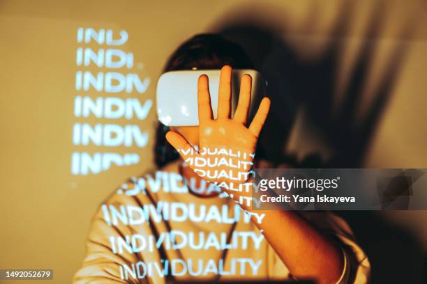 an unrecognizable person wearing vr glasses, exploring metaverse, overlayed with invididuality projection - personalização - fotografias e filmes do acervo
