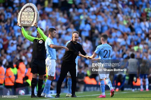 Rodri prepares looks on as he comes off the bench as a substitute whilst Pep Guardiola, Manager of Manchester City, shakes hands with Sergio Gomez as...